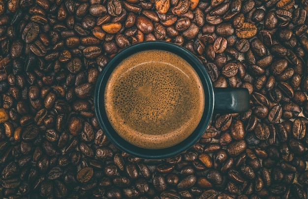 コーヒーカップと焼いたコーヒー豆の直接上のショット
