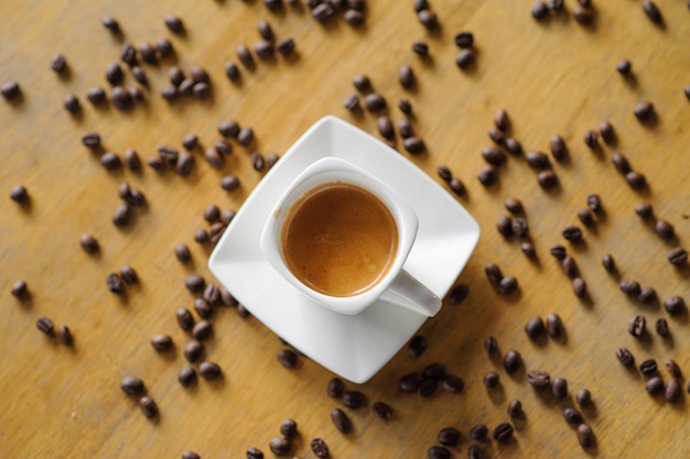 Directly above shot of coffee cup with beans on table