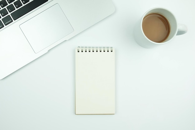 directly above shot of coffee with note pad and laptop on table