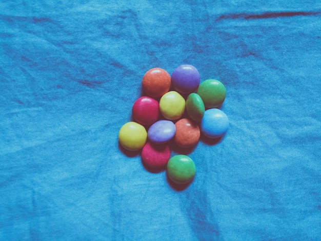 Directly above shot of colorful candies on blue fabric