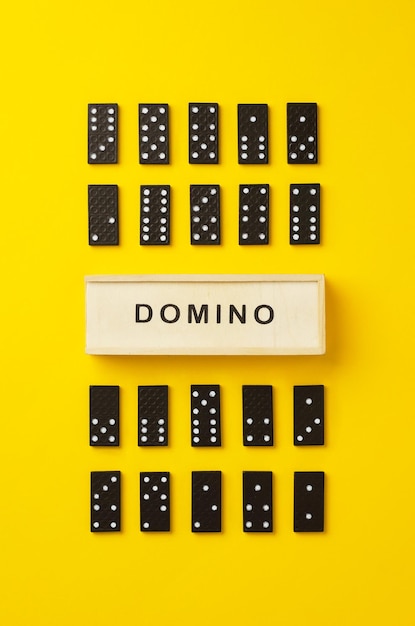 Photo directly above shot of dominoes with text on yellow background