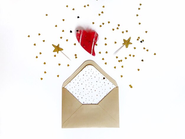 Photo directly above shot of envelope with confetti on white background