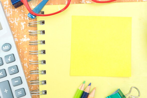 Directly above shot of eyeglasses with office supplies on table