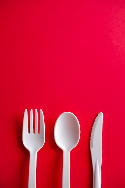 Directly above shot of fork and spoon against red background