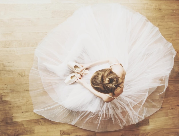 directly above shot of girl in dress sitting on hardwood floor