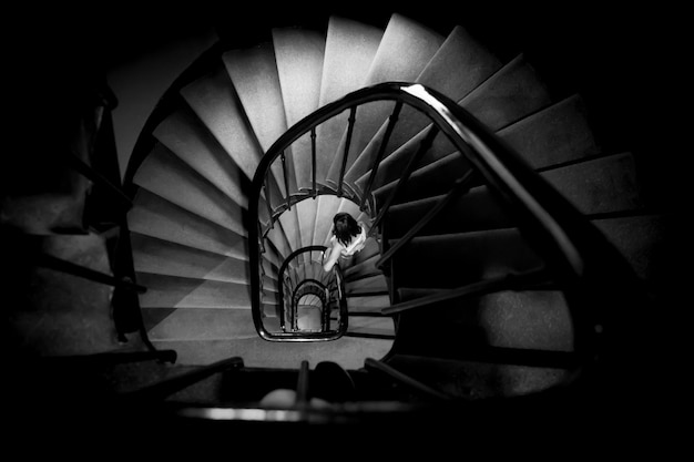 directly above shot of girl walking on spiral staircase