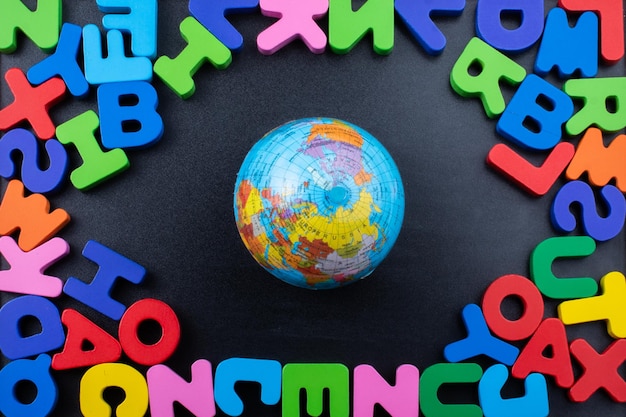 Foto scatto direttamente sopra del globo in mezzo ad alfabeti multicolori al tavolo