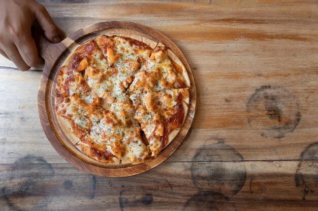 Photo directly above shot of hand holding pizza on table