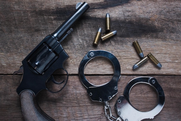 手とテーブルの上の銃の直接上のショット