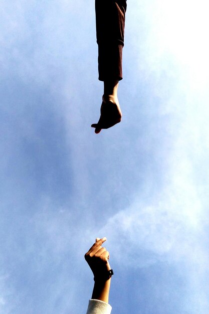 Photo directly below shot of hands against sky