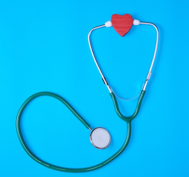 Directly above shot of heart shape with stethoscope on blue background