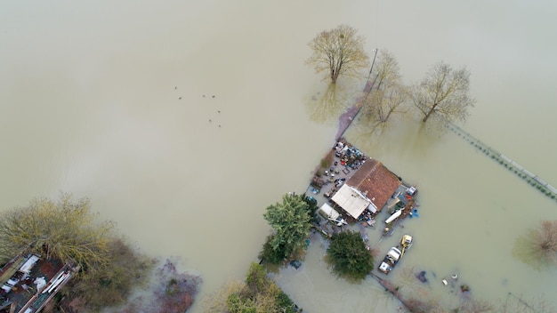 Foto immediatamente sopra la foto delle case nel fiume inondato