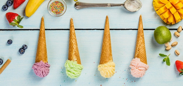 Directly above shot of ice cream cones with fruits on table