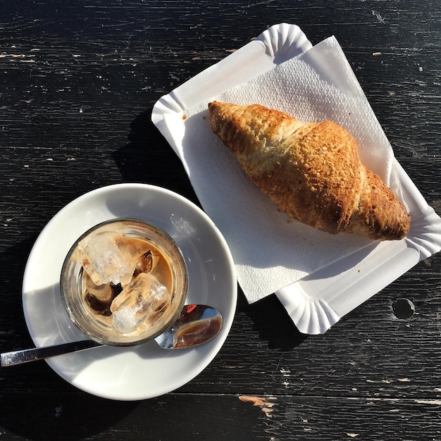 Foto direttamente sopra il colpo di caffè ghiacciato da croissant sul tavolo