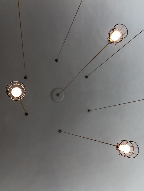directly below shot of illuminated light bulbs hanging from ceiling