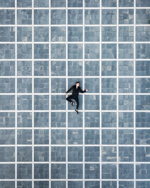 Photo directly above shot of man sleeping on tiled floor