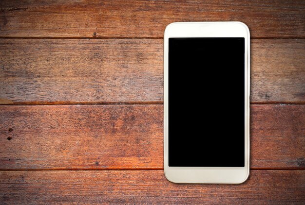 Scatto direttamente sopra il telefono cellulare su un tavolo di legno