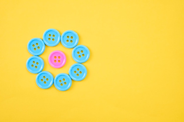 Directly above shot of multi colored buttons on yellow background