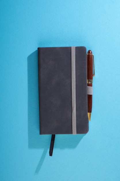 directly above shot of note pad and pens on blue background