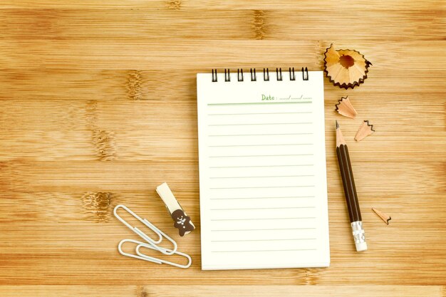 directly above shot of note pad with pencil on table