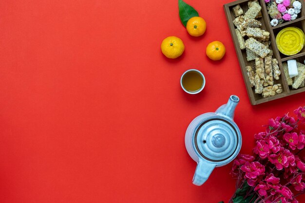 Directly above shot of oranges and sweet food with tea by ingots on table