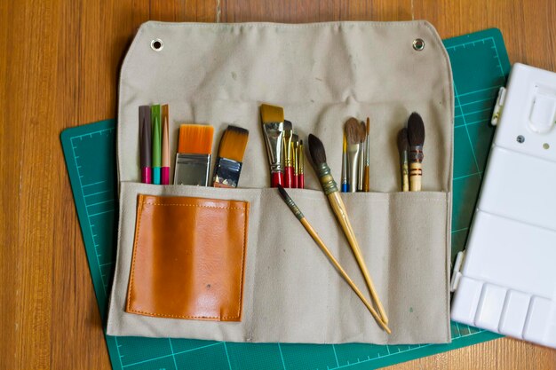 Photo directly above shot of paintbrushes in pouch on table