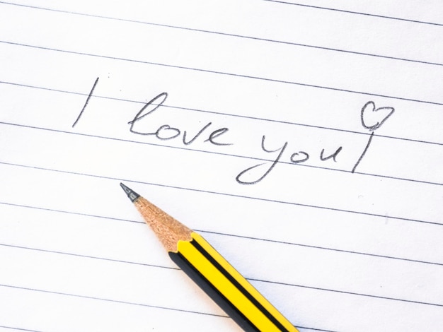 Photo directly above shot of pencil by i love you text on paper