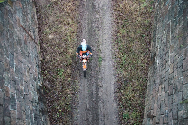 Photo directly above shot of person riding motorcycle on dirt road