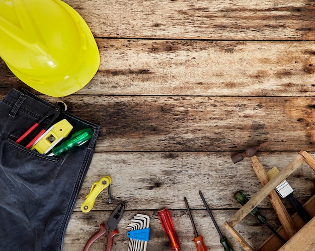 Directly above shot of phone and tools and hardhats on table