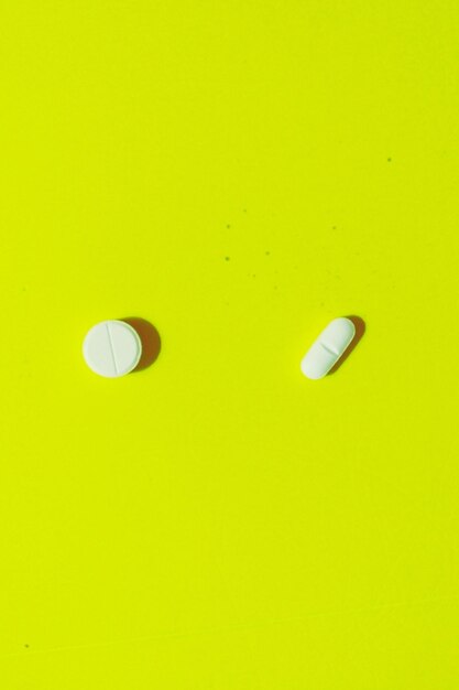 Directly above shot of pills on yellow table