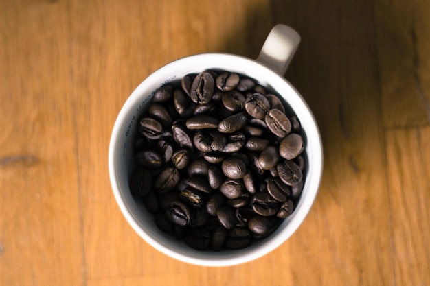 ハードウッドの床のカップに焼いたコーヒー豆のショットを直接上に