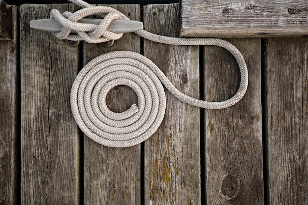 Photo directly above shot of rope tied up on cleat at pier