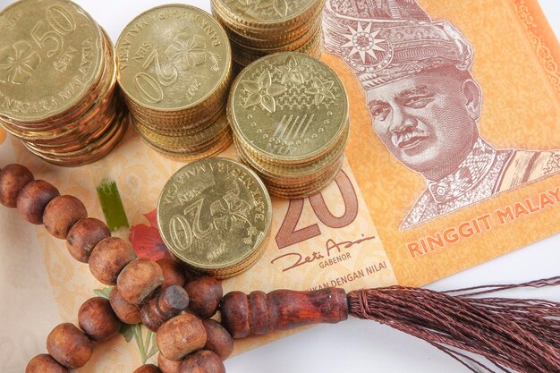 Photo directly above shot of rosary beads with malaysian currency on gray background