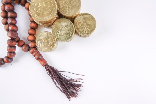 Photo directly above shot of rosary beads with stacked coins on gray background