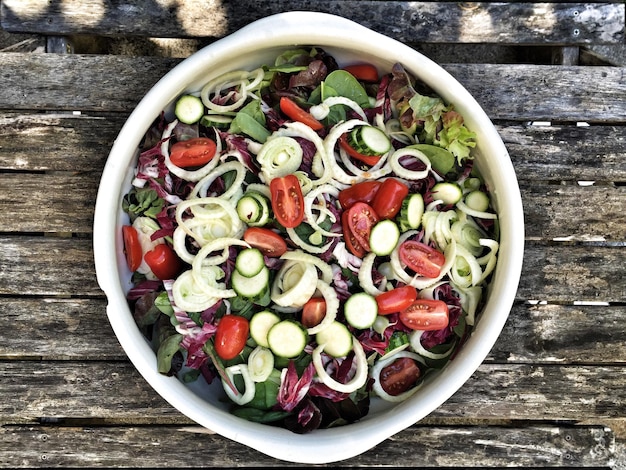 Foto direttamente sopra il colpo di insalata in una ciotola su un tavolo di legno