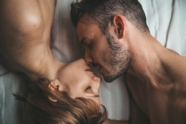 Photo directly above shot of shirtless couple on bed at home