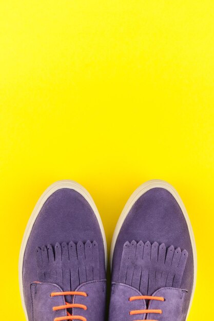 Directly above shot of shoes against yellow background