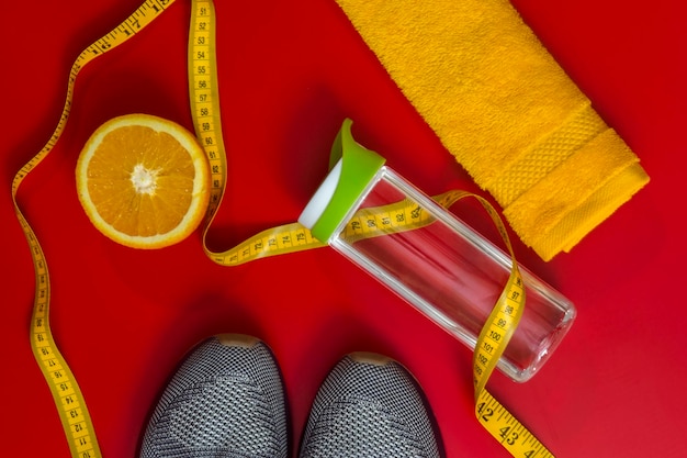 Directly above shot of shoes with bottle and orange with exercise accessories