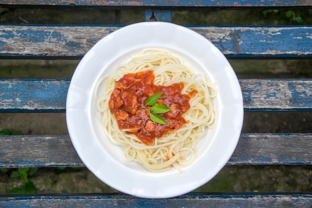 Foto direttamente sopra il colpo di spaghetti servito con la salsa in piatto su tavola