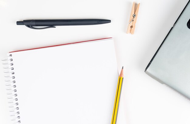 Photo directly above shot of spiral notebook and office supply on white background