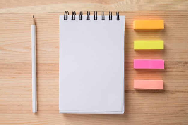 Photo directly above shot of spiral notebook with colorful erasers on table