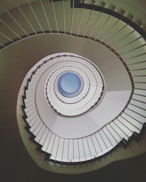 Photo directly below shot of spiral staircase against sky