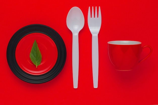 Directly above shot of spoon with fork and plate on red table