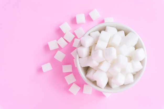 Photo directly above shot of sugar cubes in bowl against pink background