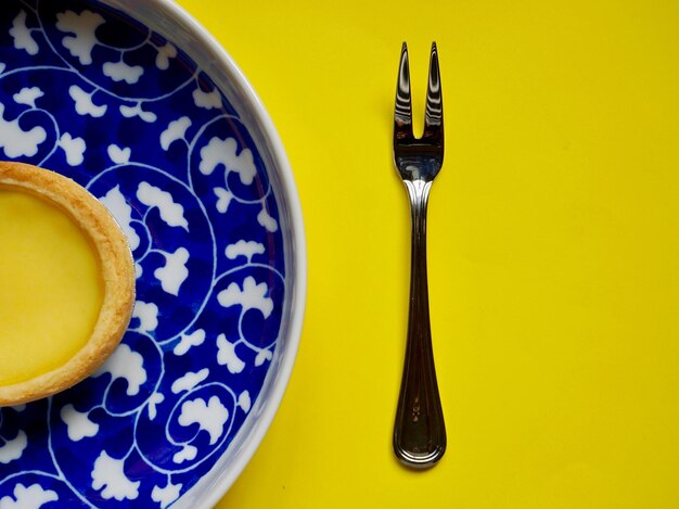 Photo directly above shot of tart in plate over yellow background