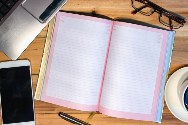 Photo directly above shot of technologies and diary on wooden table