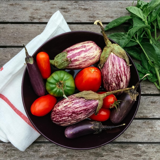 Photo directly above shot of tomatoes with eggplants and chili peppers in bowl