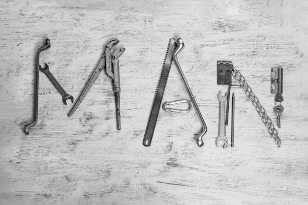 Photo directly above shot of various tools forming man text on table