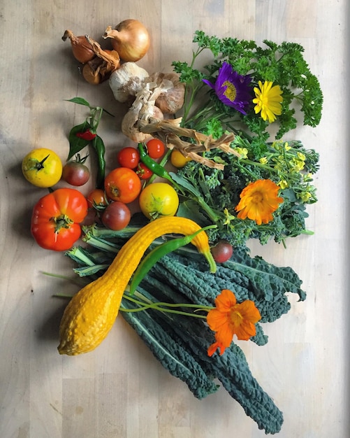 Photo directly above shot of vegetables and flowers on table