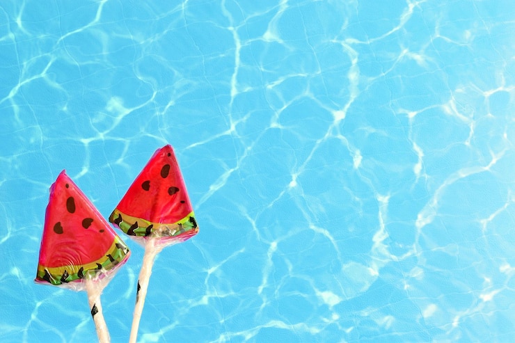 Photo directly above shot of watermelon lollipop over swimming pool